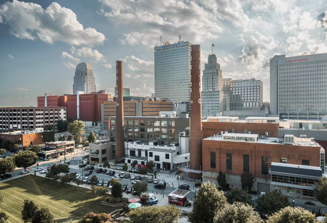 Mixed-use innovation district with historic industrial buildings and modern towers